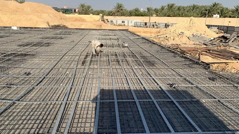 شبكتا تسليح علوية وسفلية تغطيان لبشة واسعة، مع تمديدات المواسير قبل صب الخرسانة